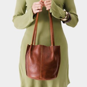 Nutmeg*Classic | Model wearing light green dress holding petite bucket shaped tote bag with matching leather handles