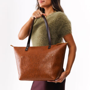 Meadow*Zipper | Model holding large zipper leather tote bag with sturdy bridle handles and front pocket